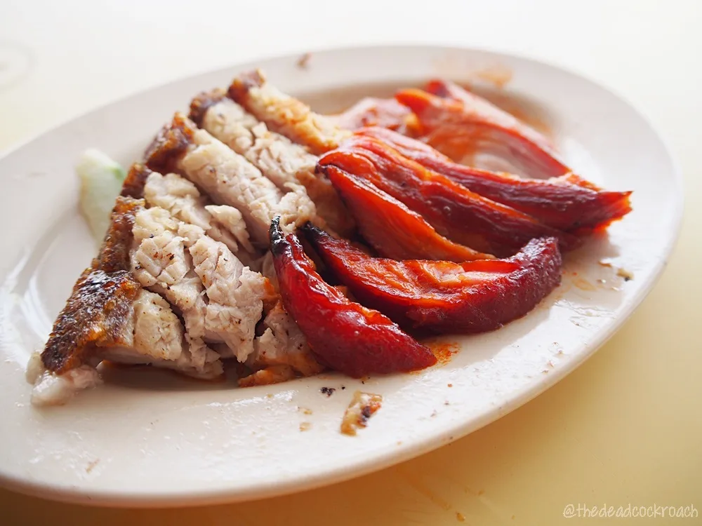 Happy World Roast char siew and roasted pork belly on a white plate, the pork skin crisp and the char siew lacquered